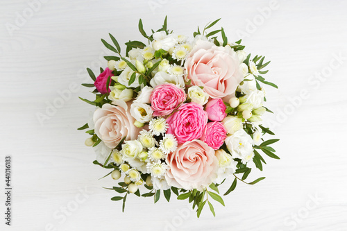 Bouquet of different flowers on white wooden table. Top view.