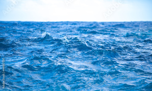 Tropical blue ocean in Hawaii. Summer sea in clean and clear water from surface for background. Waves concept design. © Volodymyr