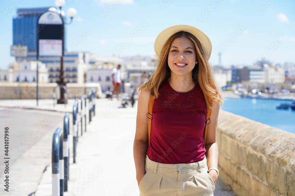 Portrait of smiling traveler woman walking relaxed on seafront