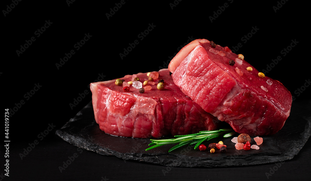 Beef steak, raw, mignon, with spices, on a black background, horizontal, no people,