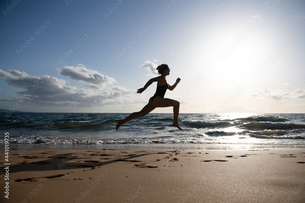 Woman running on beach. Beautiful young girl in sportswear running on sea. Woman running on beach. Beautiful young girl in sportswear running on sea.