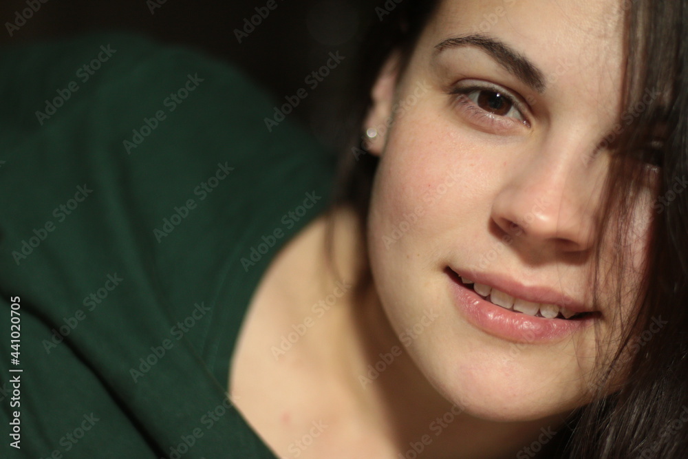 Fantastic beautiful young white dark-haired girl in a T-shirt lies on the bed with her mouth open Fantastic beautiful young white dark-haired girl in a T-shirt lies on the bed with her mouth open