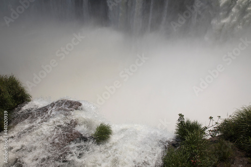 Vertigo. Amazing view of the Iguazú waterfalls seen from the Devil's Throat in Iguazú National Park, in Misiones Argentina. The falling white water, mist and splash.
