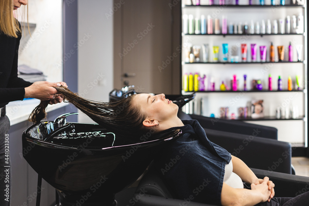 Master woman hairdresser gently washes the girl's hair with shampoo and  conditioner before styling in a beauty salon. Photos | Adobe Stock