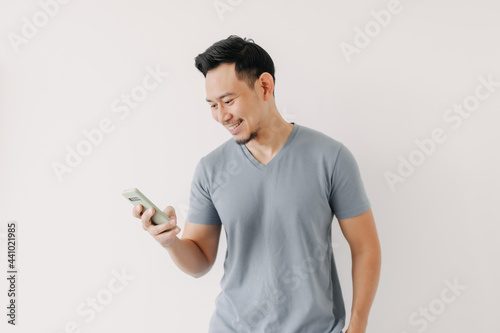 Happy Asian man use smartphone isolated on white background. © Sevendeman
