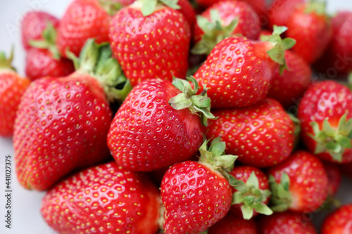 Fresh red strawberries with leaves. Pile of ripe strawberry for background