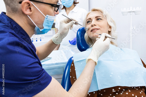 Dentistry concept. Professional dental services and modern equipment without pain. The doctor consults and treats the woman  conducts an examination and draws up a treatment plan