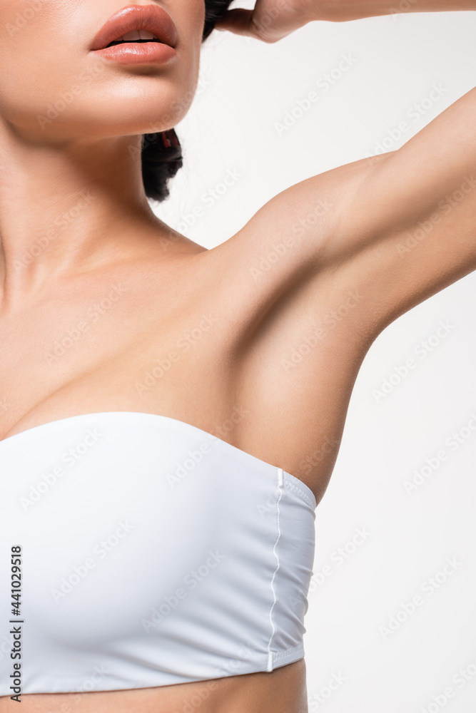 partial view of young woman in white top with smooth armpit isolated on white.