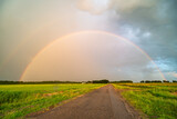 Bright double rainbow over a country road at the end of the day