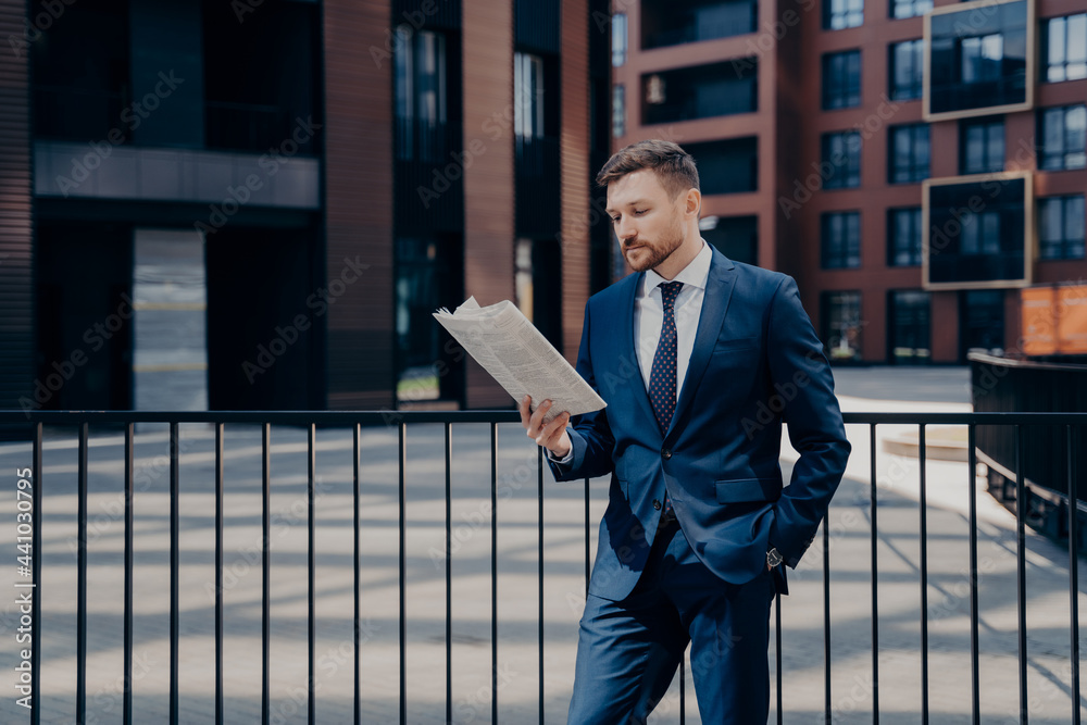 Boss reading newspaper in front of corporate building