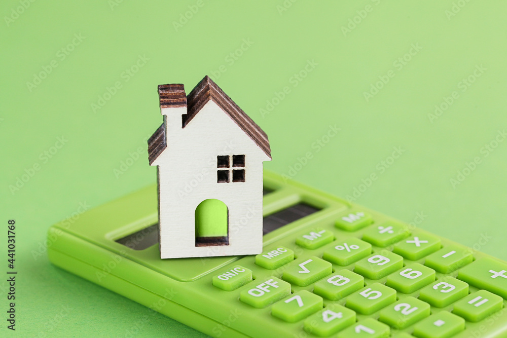 White house, green calculator on green background. Eco concept. Housing Purchase and insurance. Environmental Conservation - obrazy, fototapety, plakaty 