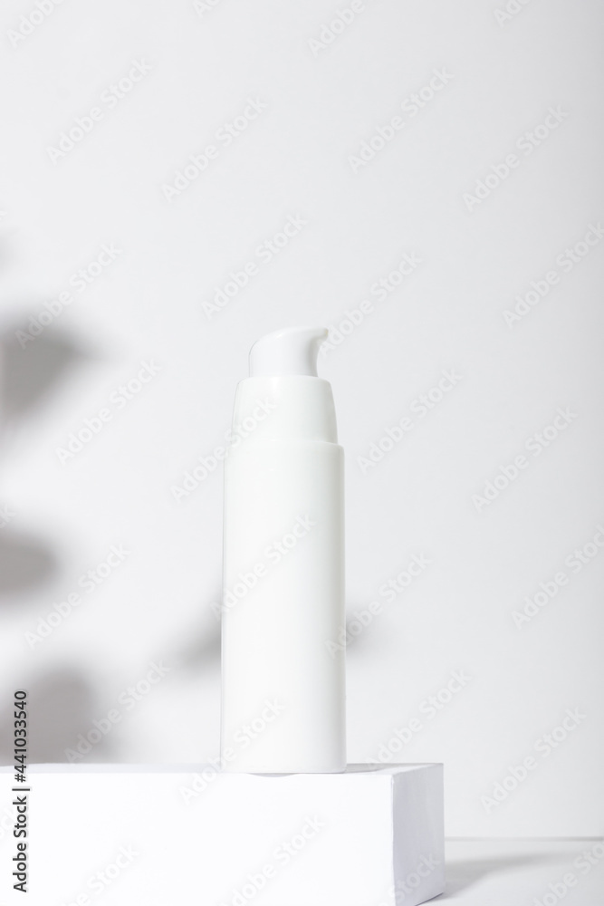 White cosmetic tube for cream, lotion, serum or face mask on the runway with leaf shadows. Professional cosmetics for skin care. Organic cosmetics. White cosmetic tube for cream, lotion, serum or face mask on the runway with leaf shadows. Professional cosmetics for skin care. Organic cosmetics.