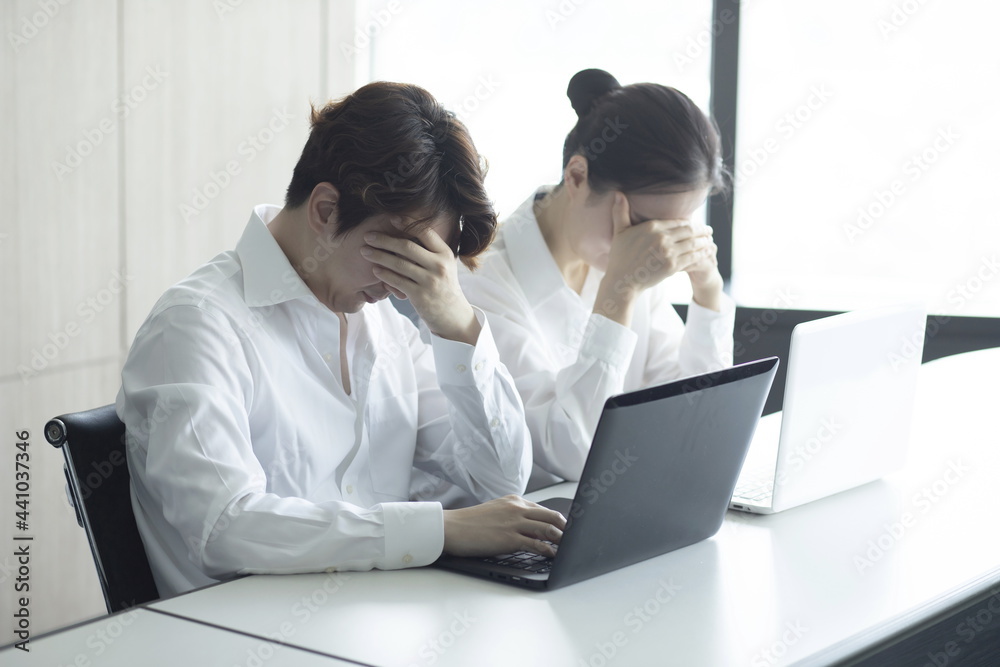 Frustrated business people with head in hands in meeting Frustrated business people with head in hands in meeting