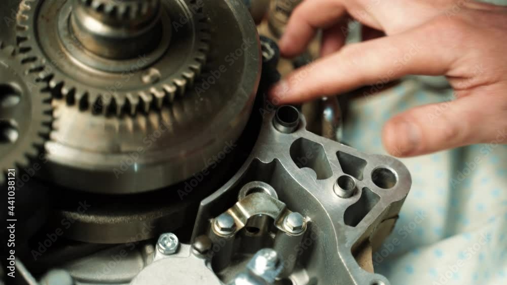 A man lubricates the engine with sealant to connect the two body parts A man lubricates the engine with sealant to connect the two body parts