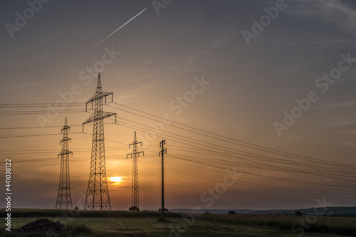 Strommasten einer Überlandleitung bei Sonnenuntergang