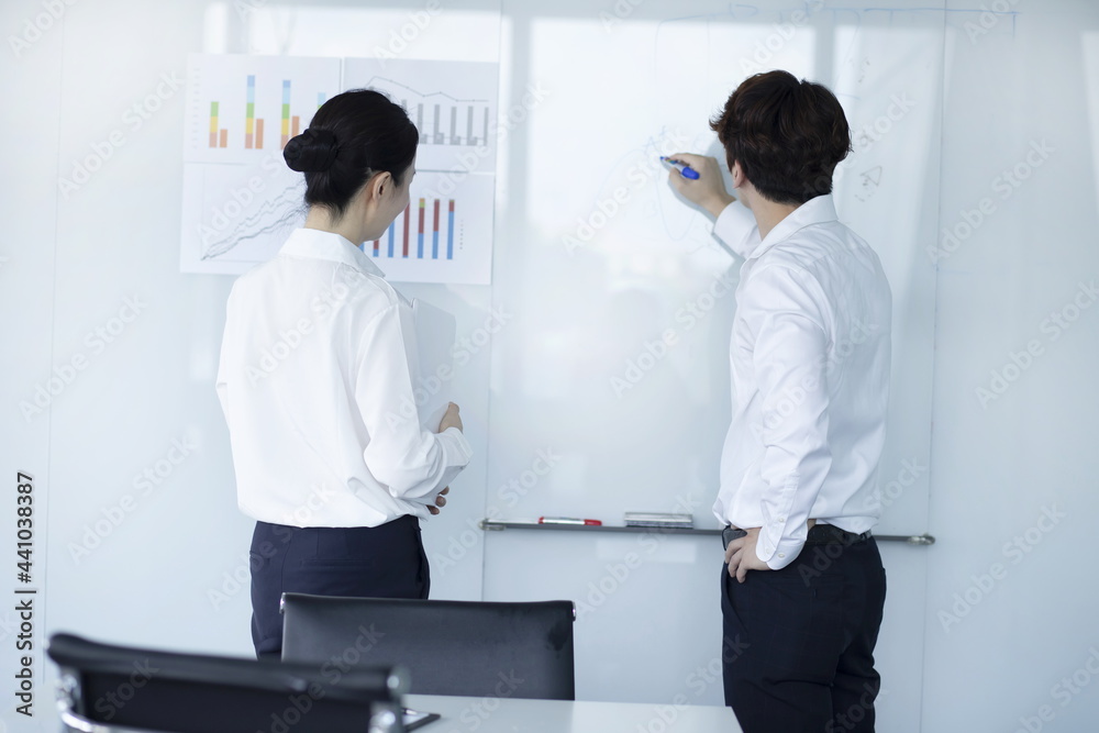 Naklejka premium Businessman Explaining and Pointing at Chart on Board