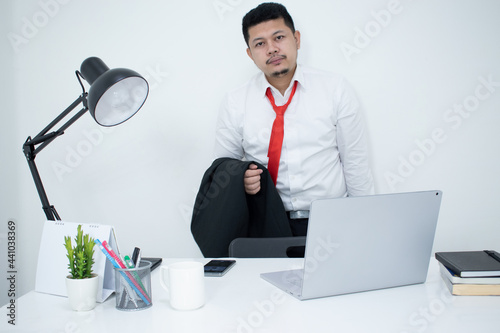 Head shot thoughtful businessman in eyewear looking at computer screen, sitting at table at home. Pensive confused young man thinking of problem solution stuck with task, working with laptop remotely.
