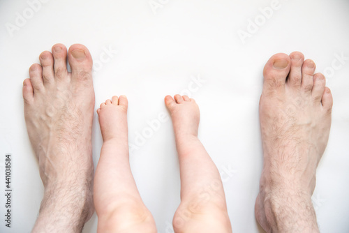 Little baby feet with father feet top view