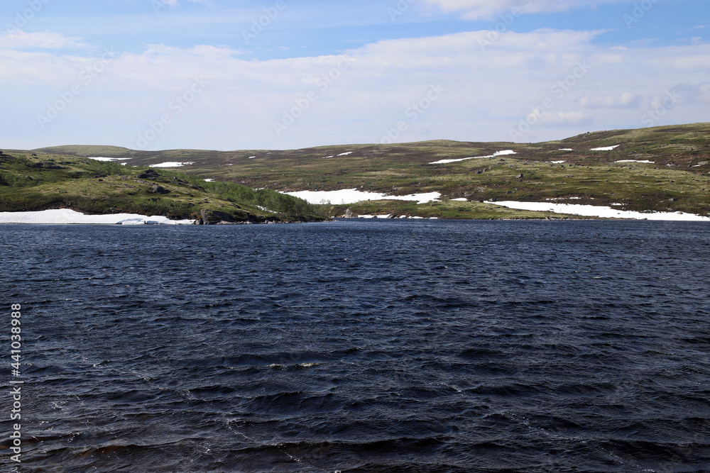 blue waters of the northern lake on the background of the tundra