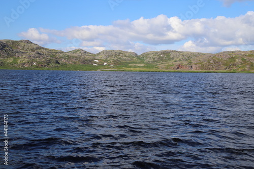 blue waters of the northern lake on the background of the tundra