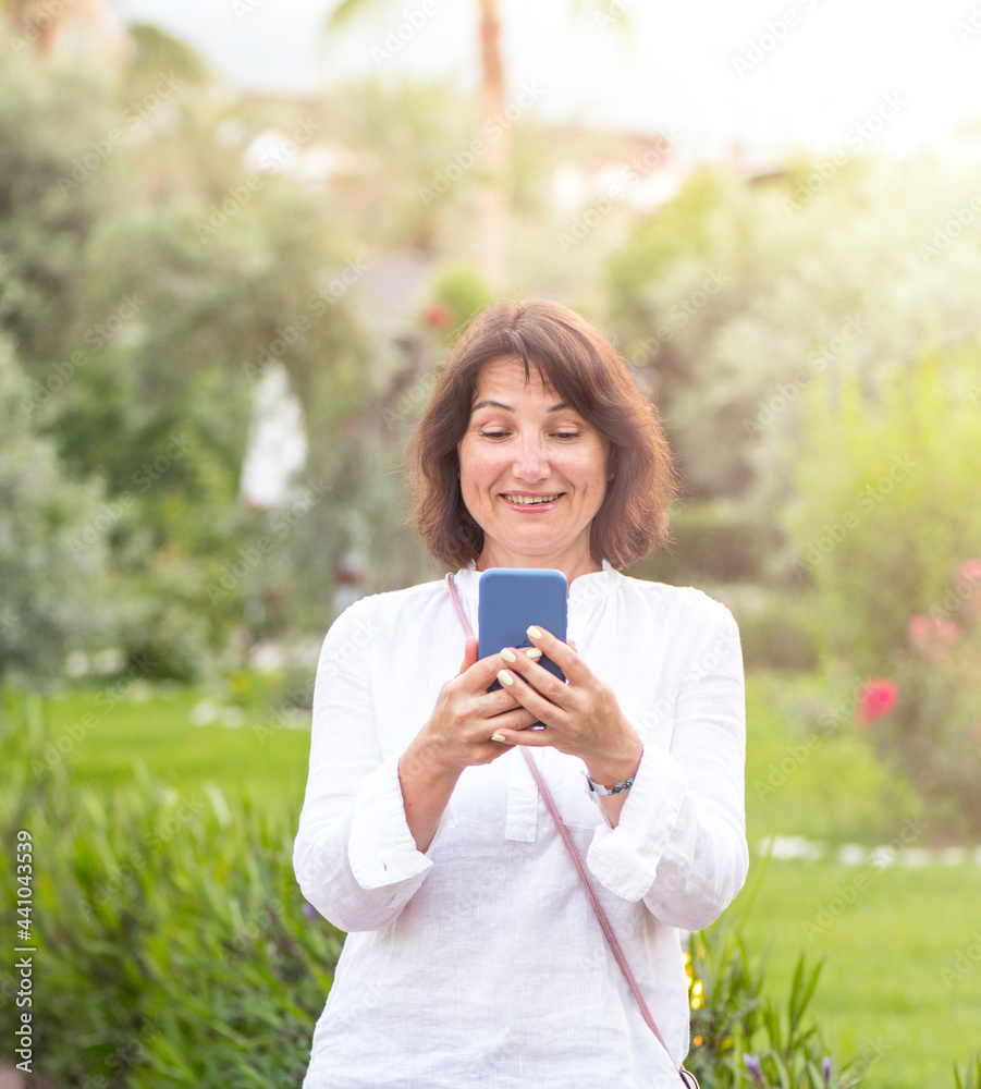 A beautiful woman communicates with delight on a mobile device, smartphone, phone through applications A beautiful woman communicates with delight on a mobile device, smartphone, phone through applications