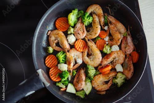 Cooking vegetables and shrimps on pan