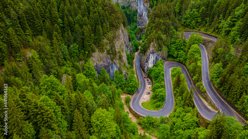Winding road in the mountains, shot from a drone from a lower altitude and a low camera angle. Photography of a serpentine road in the mountains.