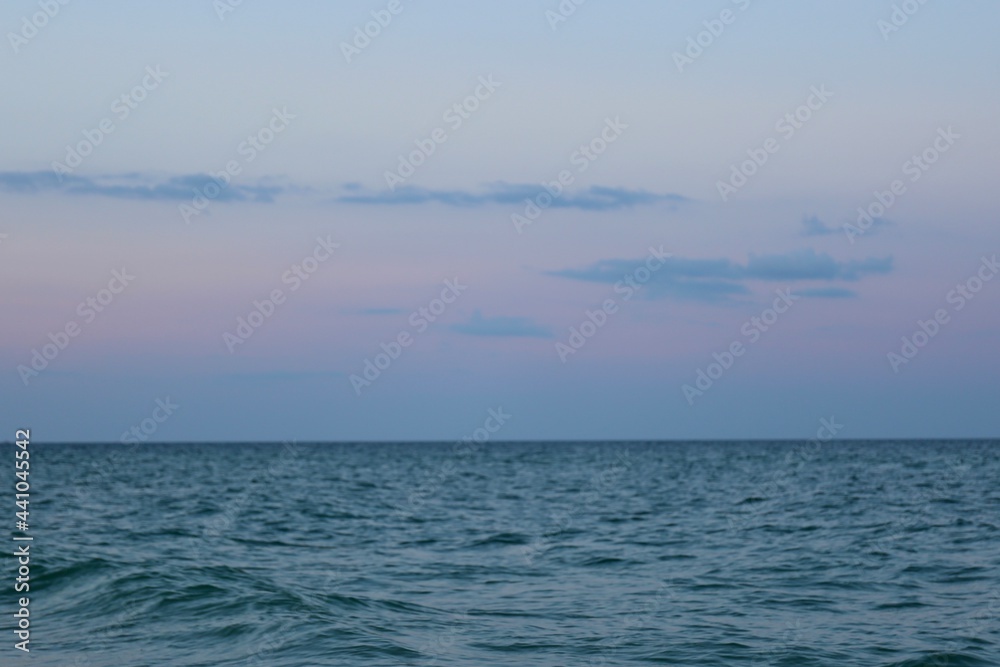 gentle beautiful pink sunset in the sky against the background of the sea