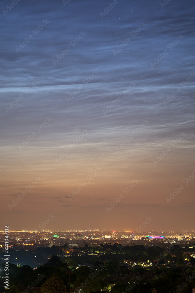 Fototapeta premium Beautiful closeup view of stars visible through very rare noctilucent clouds seen in Dublin, Ireland on summer solstice of 2021 before midnight. Details of NLC. Night shining
