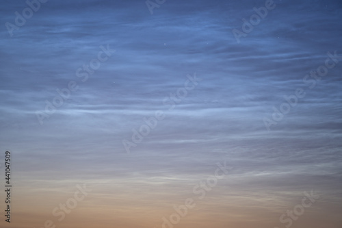 Beautiful closeup view of stars visible through very rare noctilucent clouds seen in Dublin, Ireland on summer solstice of 2021 before midnight. Details of NLC. Night shining
