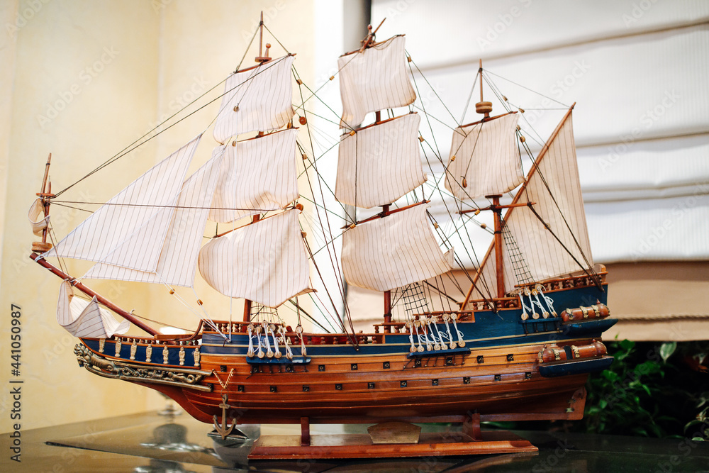 Fotka „Wooden old sail ship model on a stand on a glass table. It has