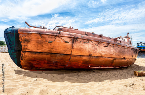 Old river motor boat on the sandy bank of the river