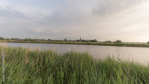 The Amstel river with the town of Nes aan de Amstel in the background during the evening photo