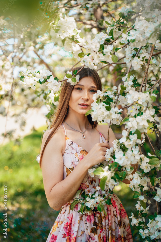 Portrait of a beautiful cute girl in blooming apple orchards