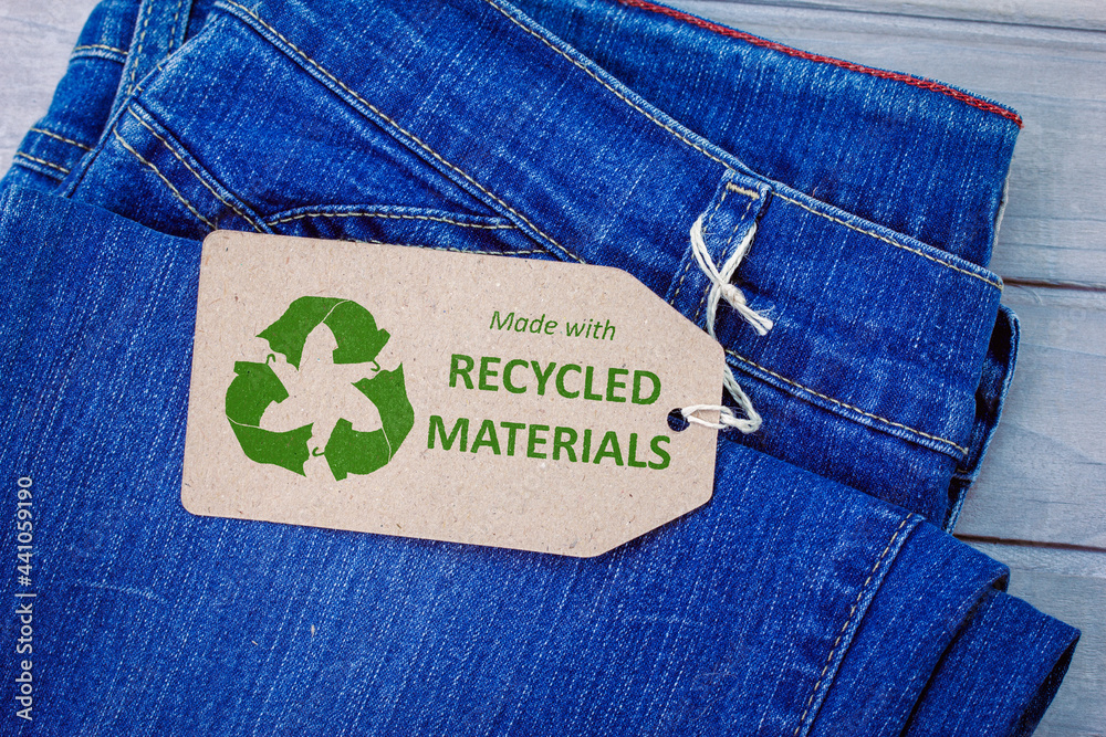 Made with recycled materials label on jeans with eco clothes icon.  Sustainable fashion and ethical shopping concept Stock Photo | Adobe Stock