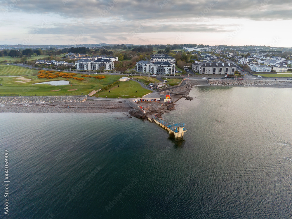 Blackrock public diving board at sunrise. Salthill, Galway city, Ireland. Popular town landmark. Aerial drone view. Dramatic light, High tide.