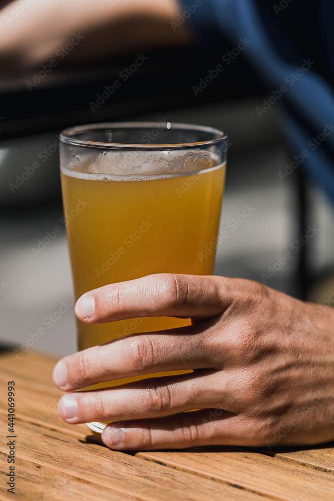 person holding a glass of cold beer in the bar person holding a glass of cold beer in the bar