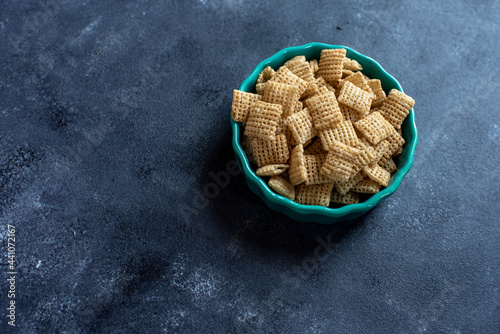 Chex cereal in a teal container on a dark background. photo