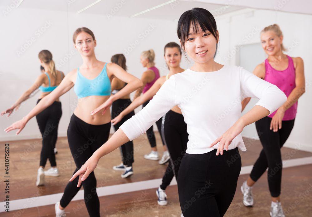 Fototapeta premium Girl of chinese appearance dances in a group of dancers
