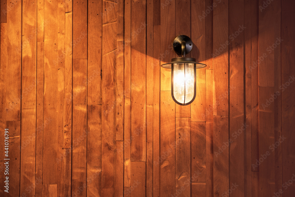switched on lamp bracket at the wooden wall