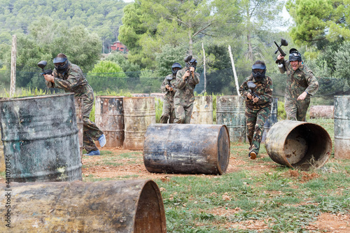 Dynamic paintball battle. Group of players in camouflage attacking opposite team