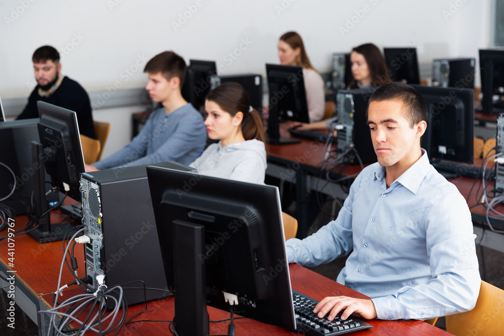 Fototapeta premium Portrait of adult concentrated students at computers in university computer class