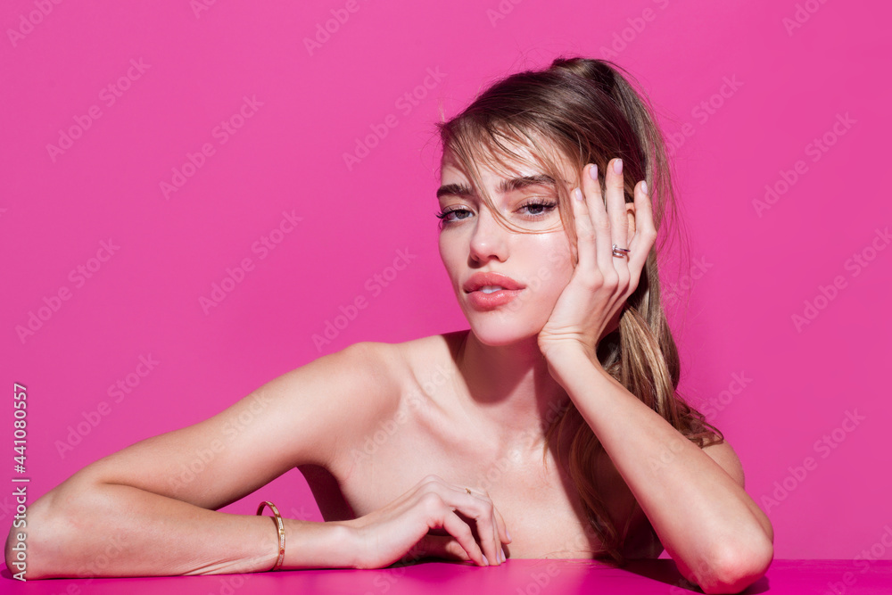 Woman face. Portrait of sensual young female model. Pretty young excited woman holding empty blank board. Colorful studio portrait with pink background. Woman face. Portrait of sensual young female model. Pretty young excited woman holding empty blank board. Colorful studio portrait with pink background.