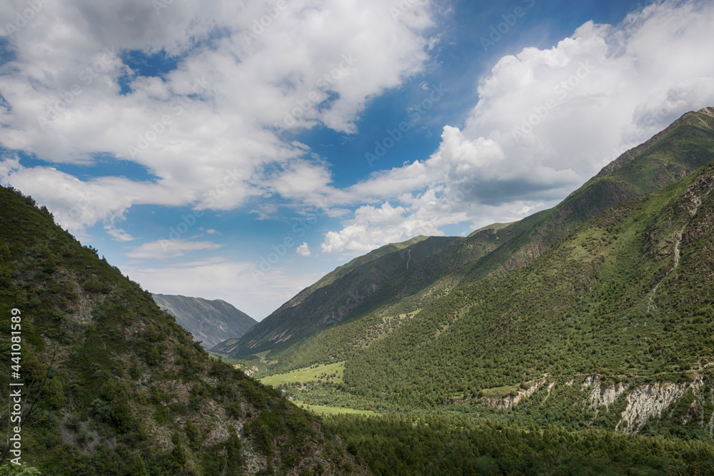 Idyllic winter landscape with hiking trail in the mountains. Rocks, snow and stones in mountain valley view. Mountain panorama.