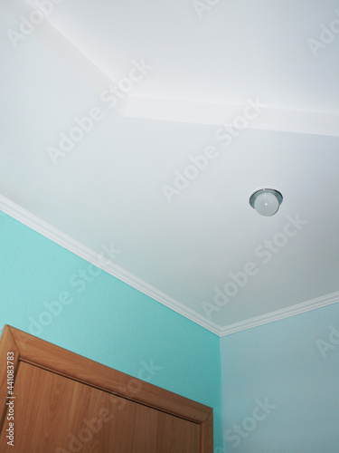 Room. Corner of the room. Ceiling with light bulb and part of the door.                              