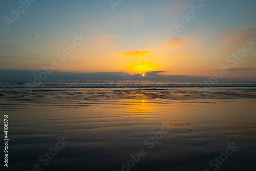 Fototapeta Naklejka Na Ścianę i Meble -  Calm sea with sunset sky and sun through the clouds over. Ocean and sky background, seascape.