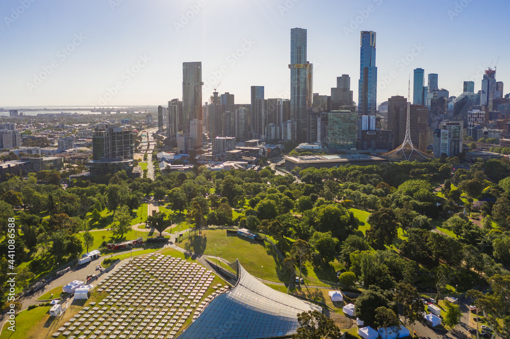 Aerial view of an outdoor auditorium in parkland in front of a city skyline
