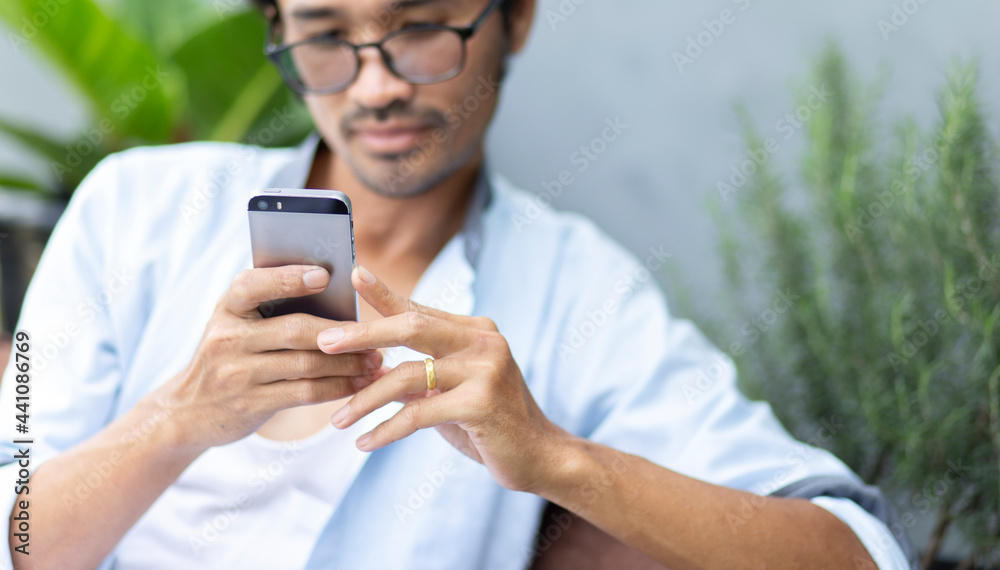 happy young man using smartphone during relaxing time at home focus on hand holding smartphone happy young man using smartphone during relaxing time at home focus on hand holding smartphone