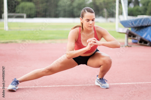 young woman stretching and warming up for running