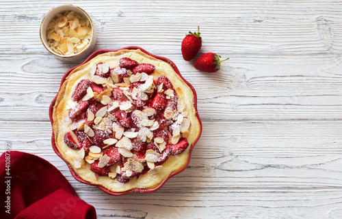 Strawberry and almond homemade tart on white wooden background